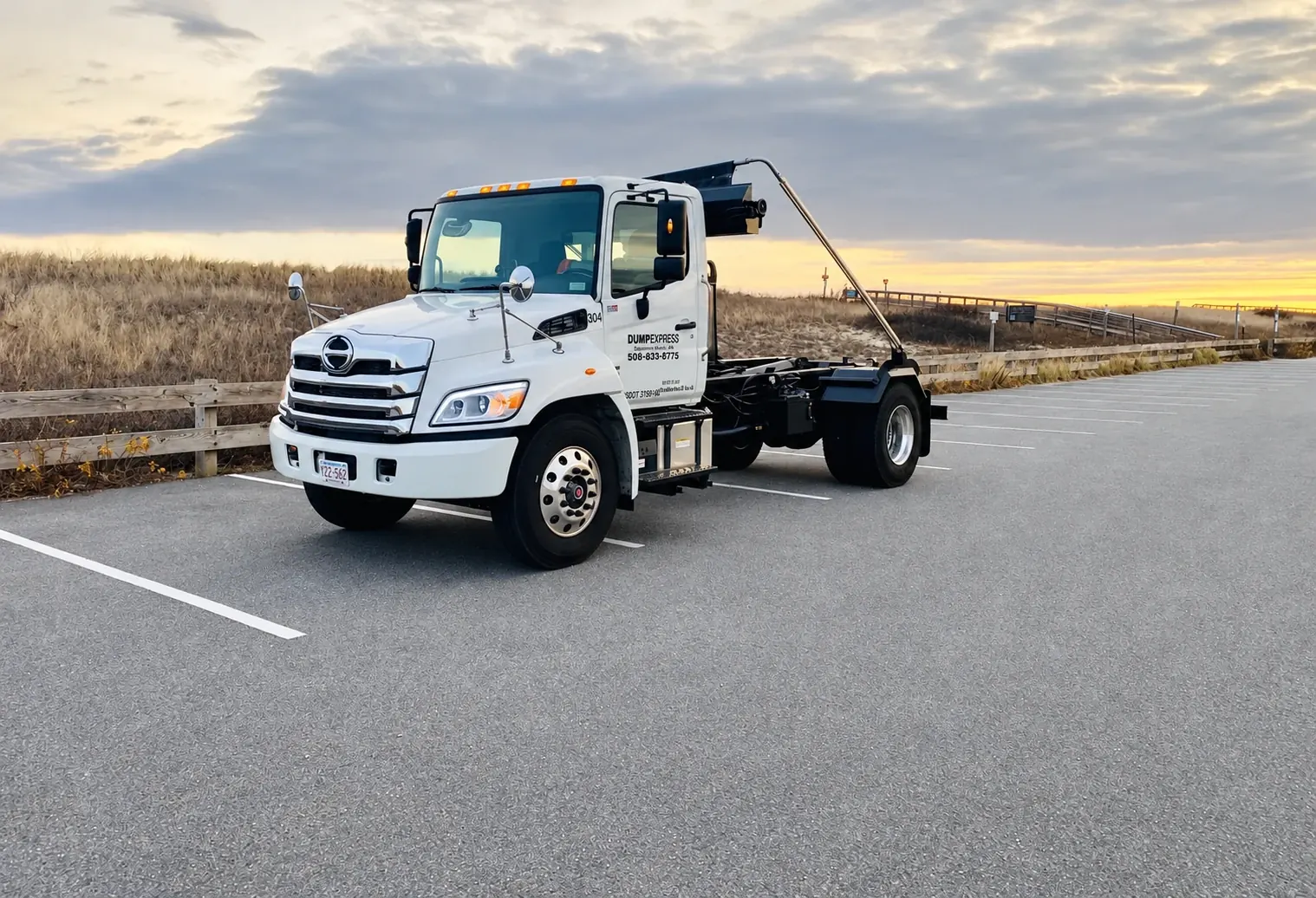Dump Express roll-off delivery truck beside the Cape Cod dunes